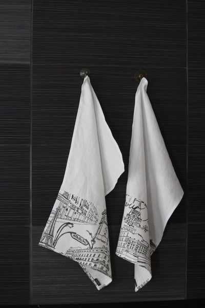 White linen dish towels with black Parisian images, hanging