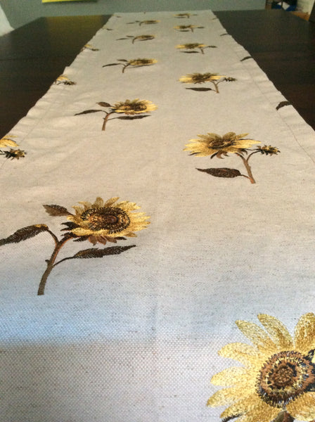 Embroidered sunflower table runner on natural linen like background