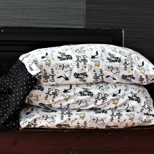 flannel pillowcases on stacked pillows in white with black and gold Paris themed print