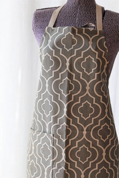 full apron in a taupe and ivory geometric print displayed on a mannequin