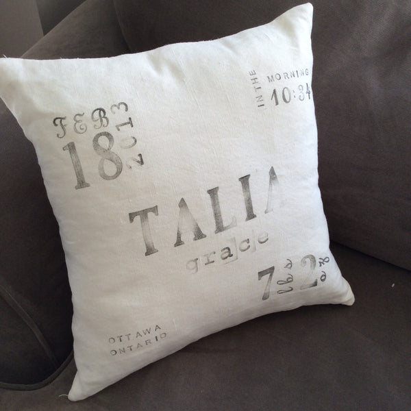 ivory linen ink-stamped birth announcement pillow on chair
