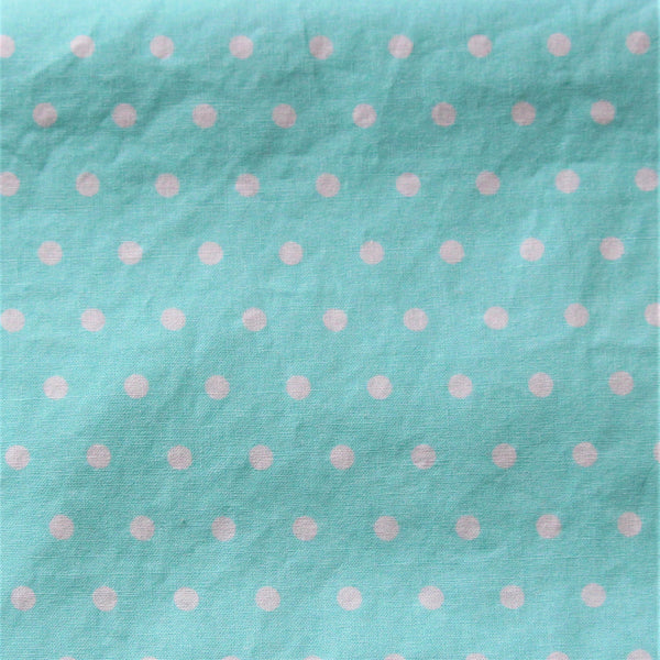 Close up of a piece of aqua coloured fabric with evenly spaced white polka dots