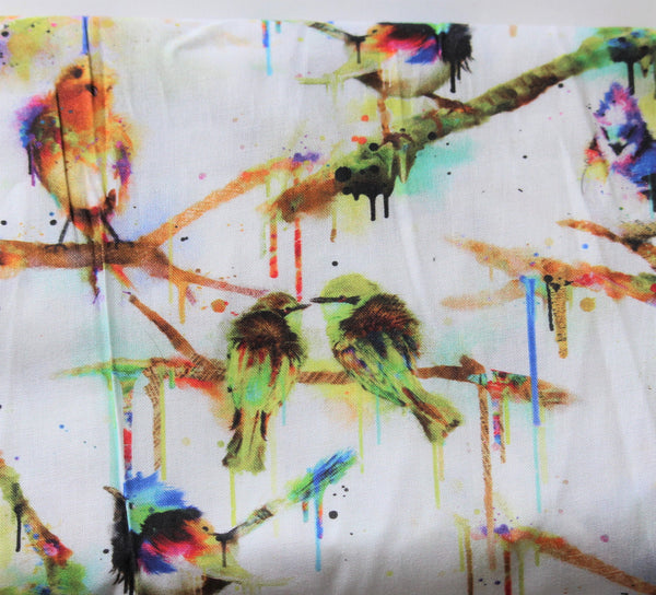 Close up of a piece of fabric with brightly coloured birds that appear painted, complete with paint drips, on a white background.