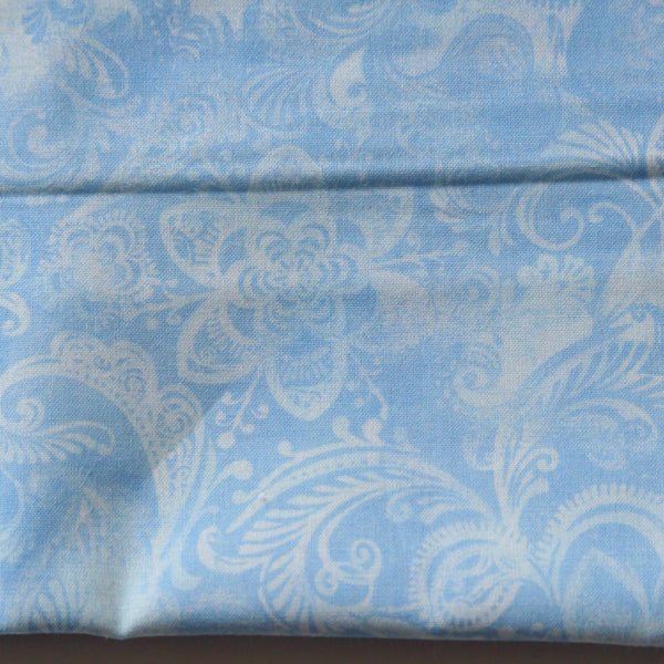 Sky blue fabric with a delicate white floral and paisley pattern